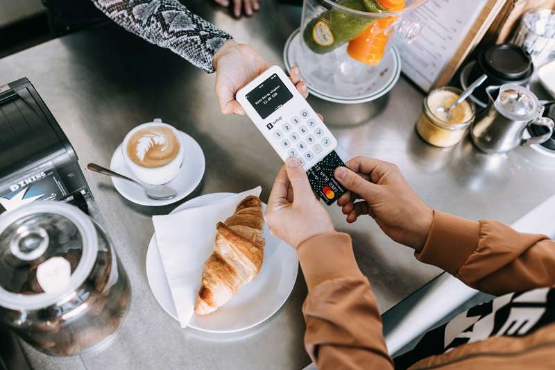 Person paying their breakfast with a bank card