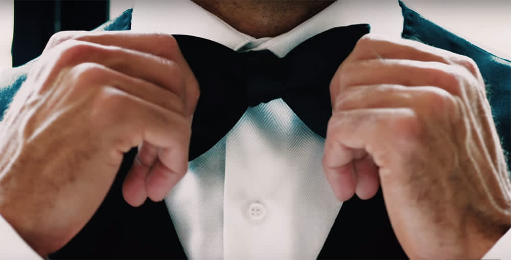 Man adjusting his bow tie